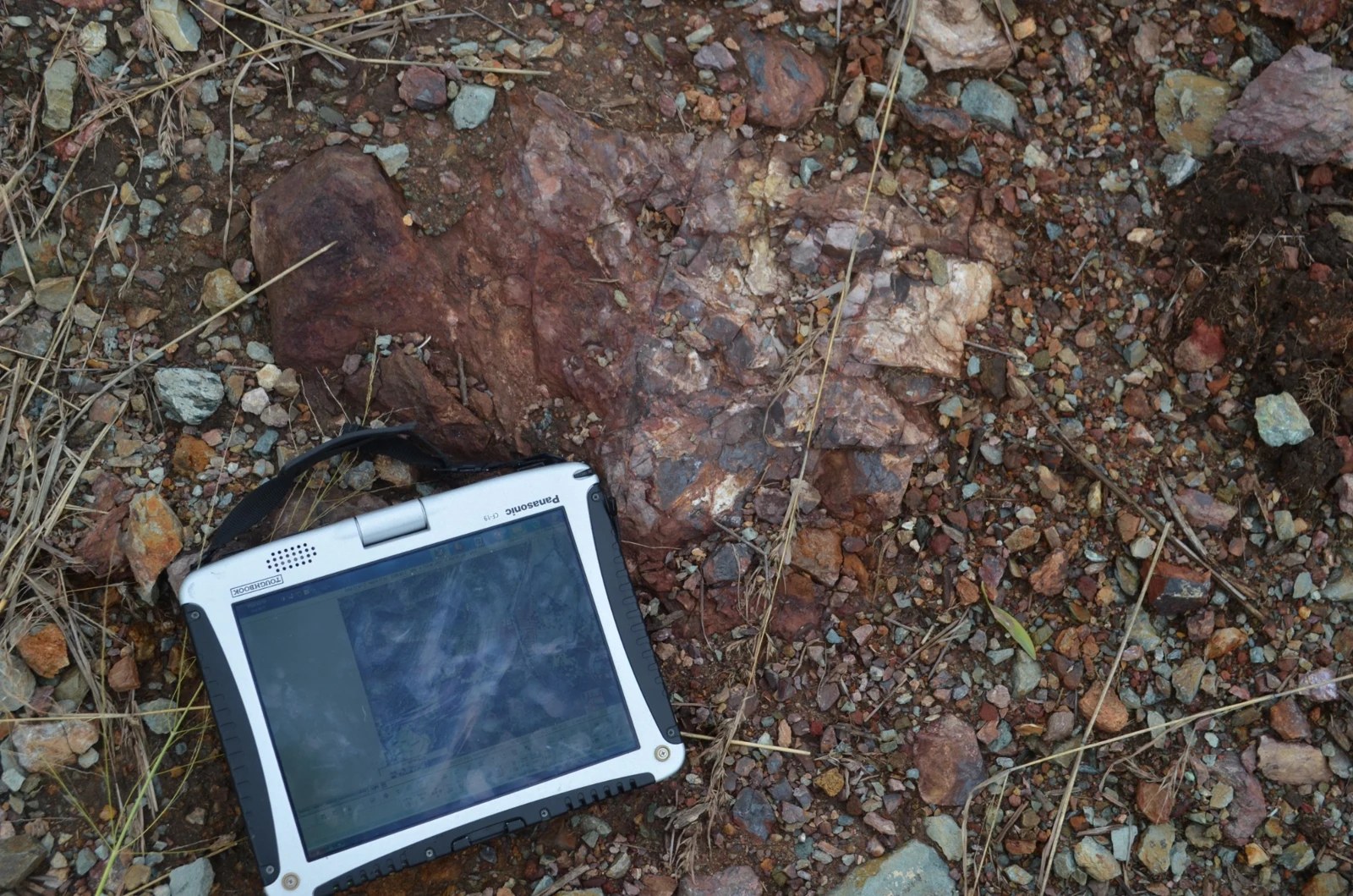 A field computer beside a rock outcrop.