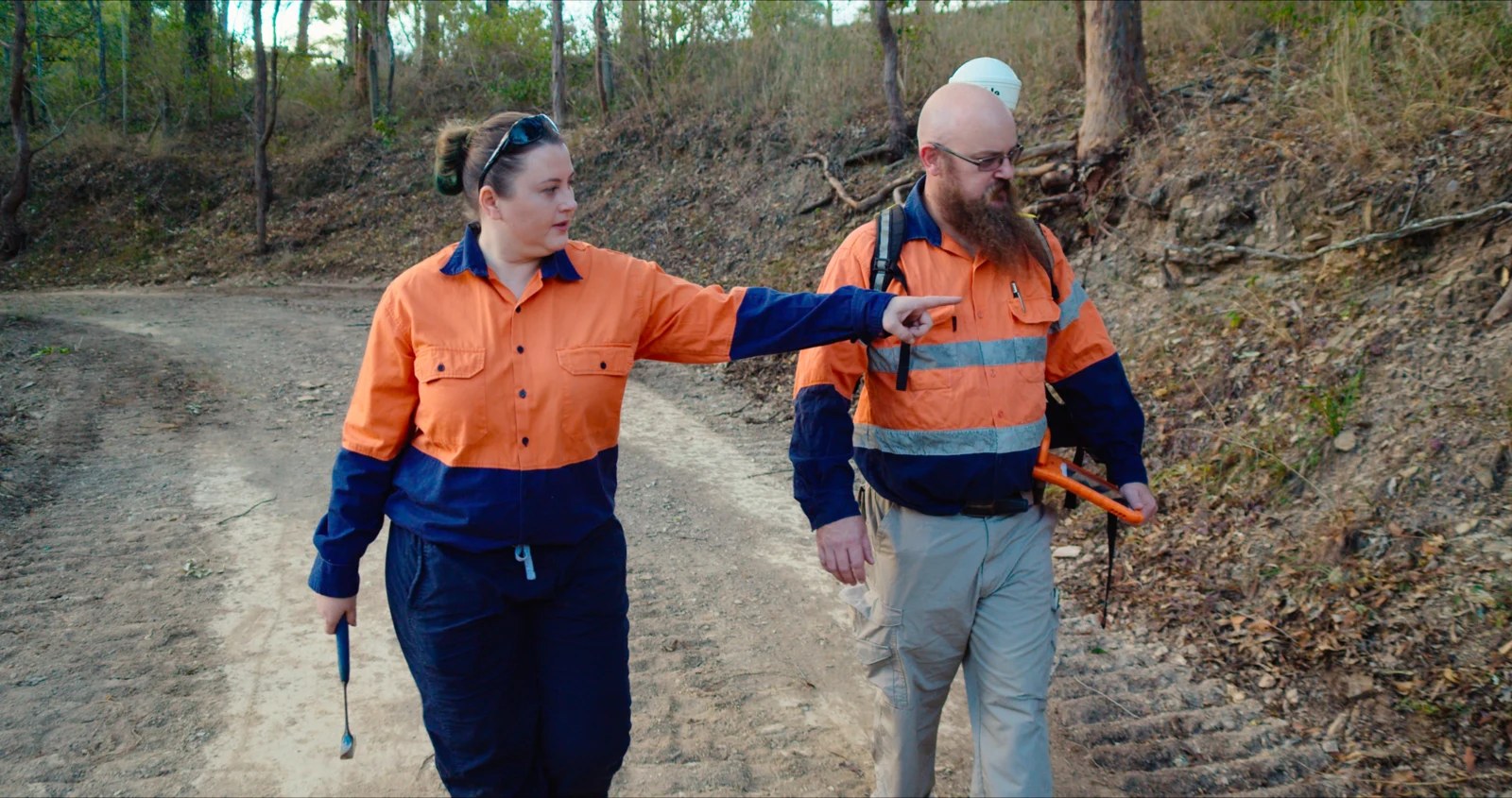 Two exploration personnel examining an area in the field.